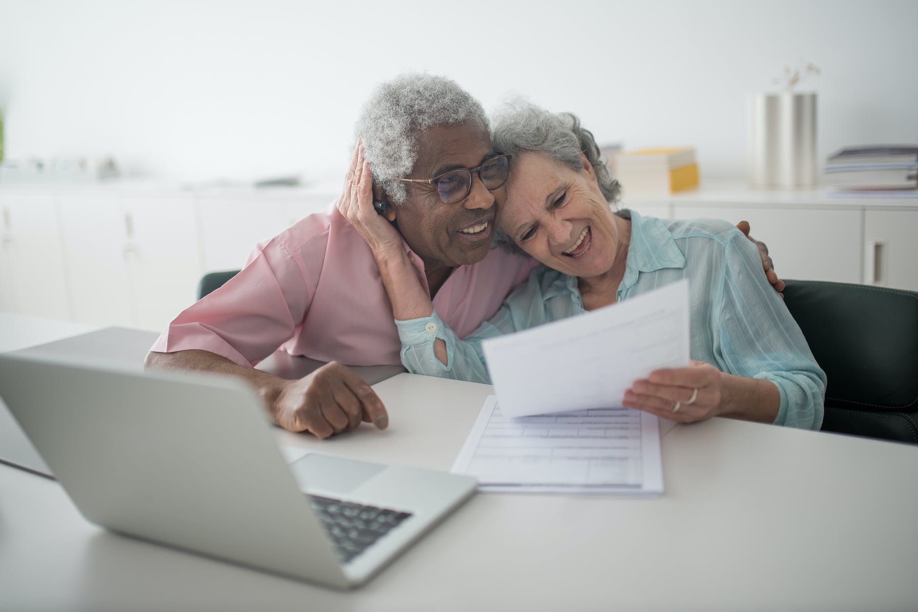 a happy elderly couple holding a document